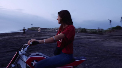 a woman riding on the back of a red motorcycle