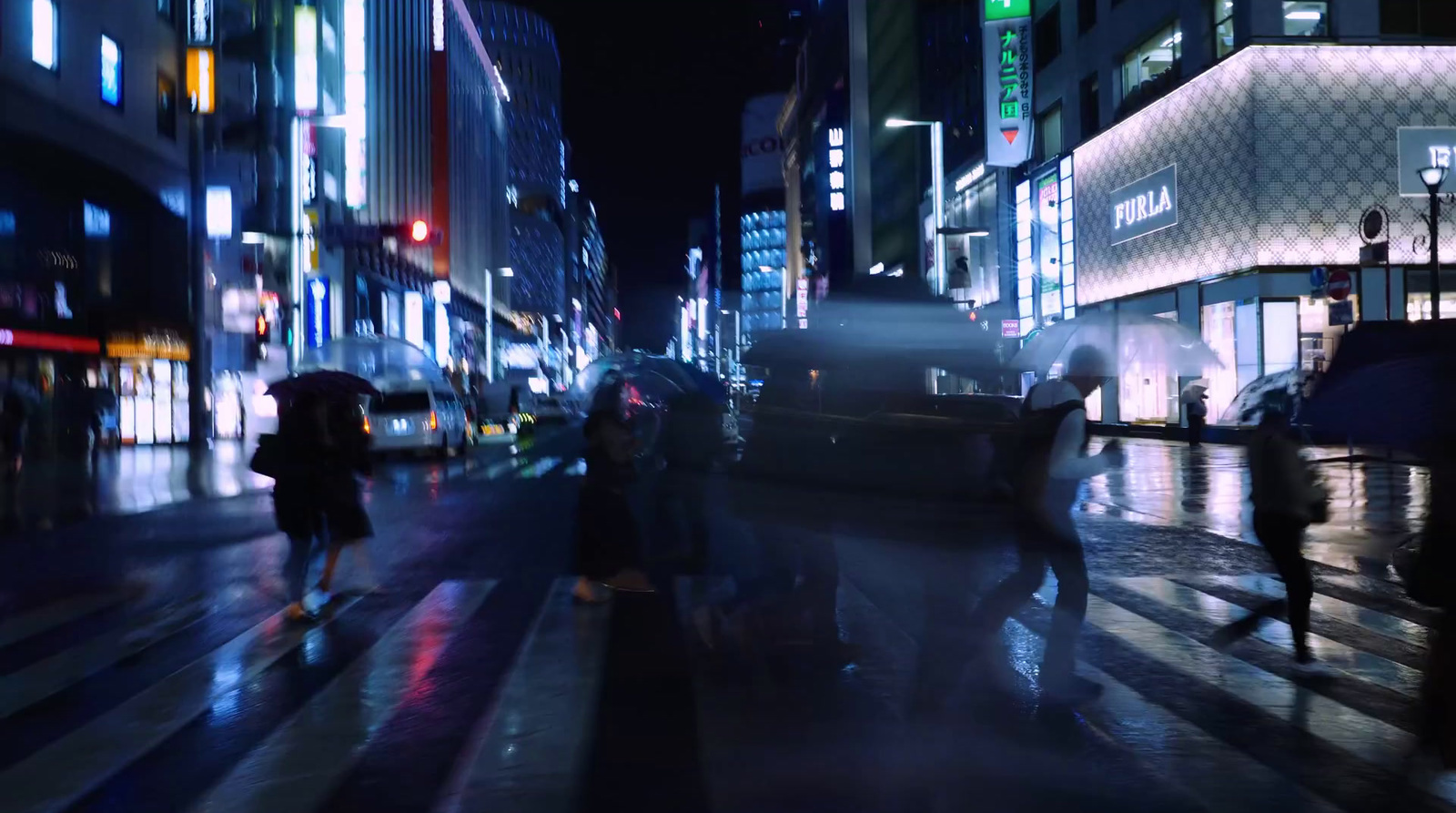 a group of people walking down a street at night