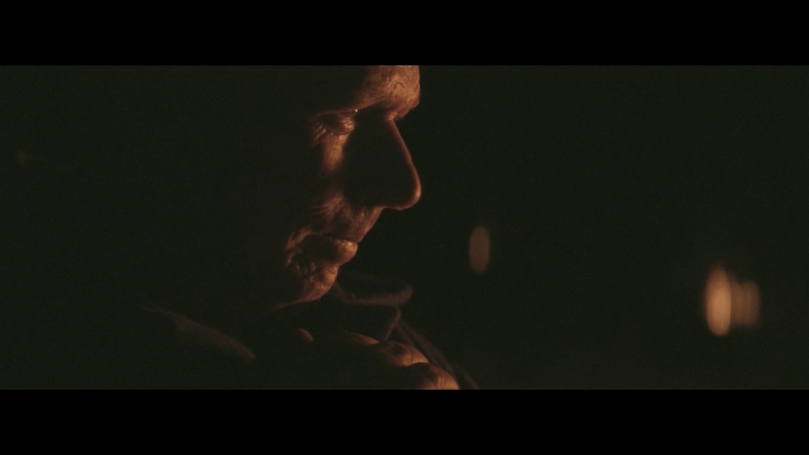 a man smoking a cigarette in the dark