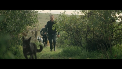 a man walking down a path next to a dog