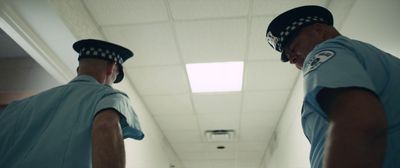 a couple of men standing next to each other in a hallway