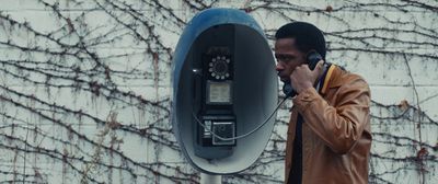 a man talking on a cell phone next to a parking meter