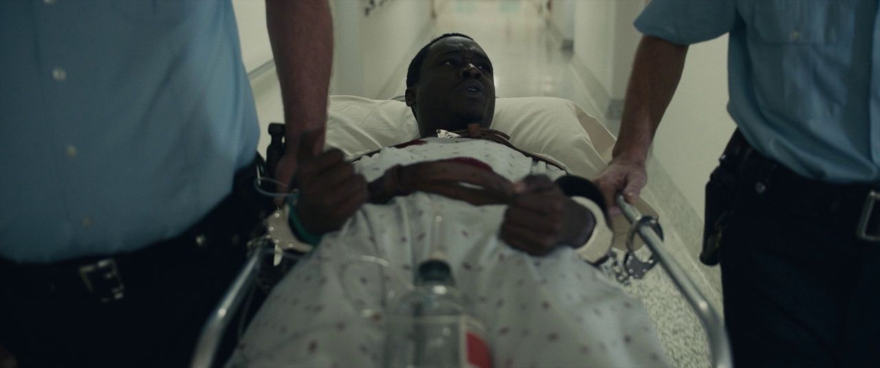 a man in a hospital bed being wheeled by two men