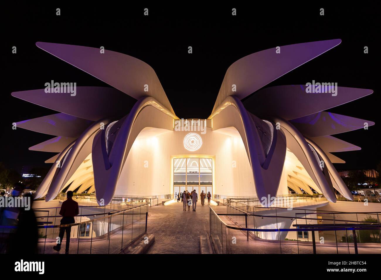 the entrance to the museum of modern art at night with people walking in front of