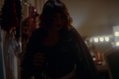 a woman standing in a living room next to a christmas tree