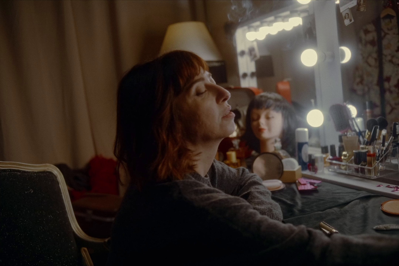 a woman sitting at a table in front of a mirror