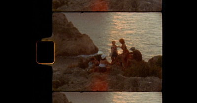 a group of people sitting on top of a rocky beach