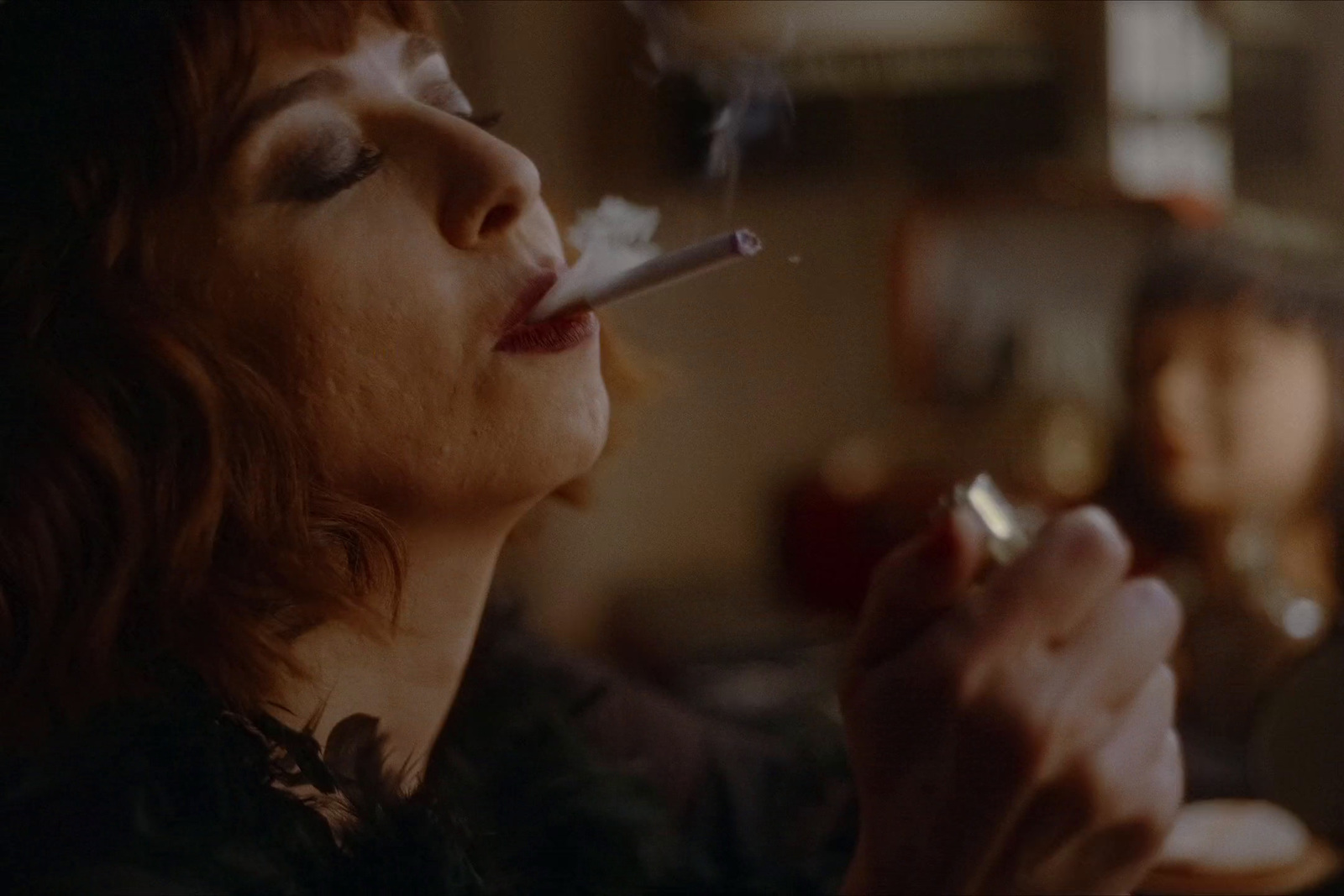 a woman smoking a cigarette in a dark room