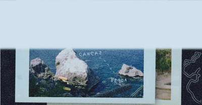 a polaroid photo of a rock outcropping in the ocean