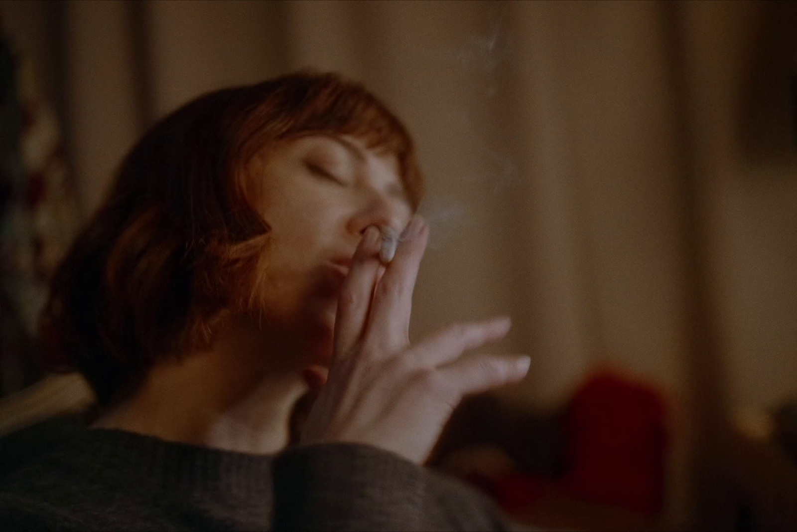 a woman smoking a cigarette in a dark room