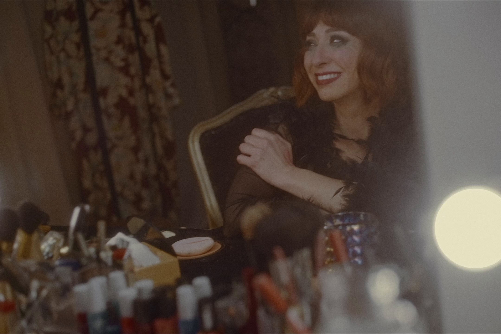 a woman sitting in a chair in front of a mirror