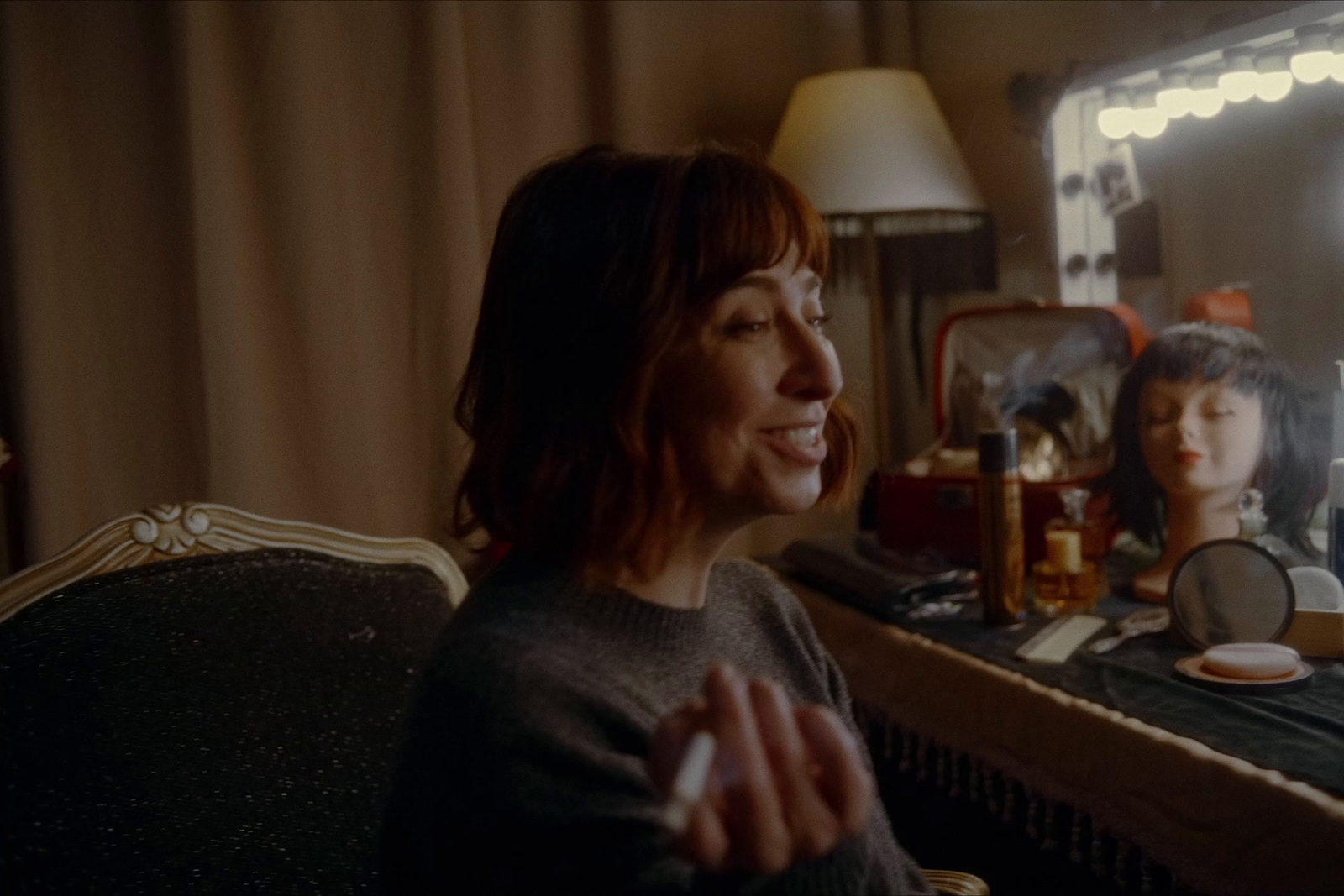 a woman sitting in a chair in front of a mirror