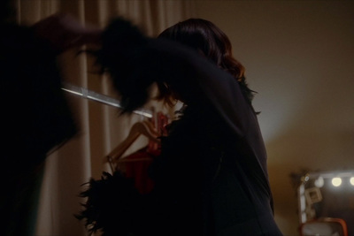 a woman holding a knife in a dark room