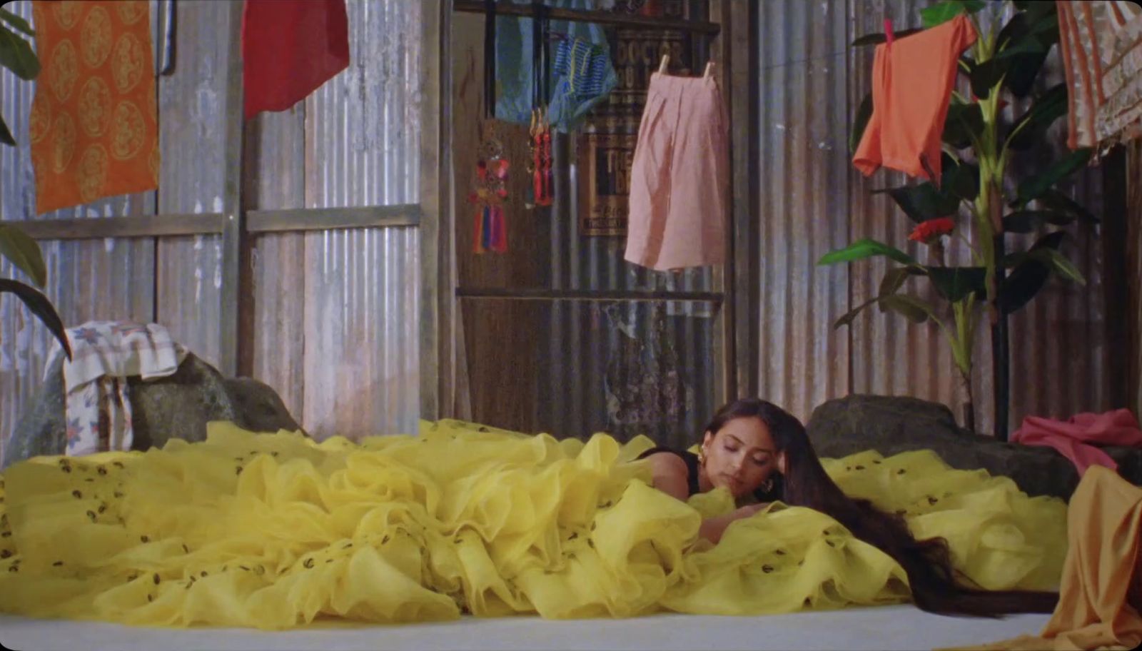 a woman laying in a bed covered in yellow sheets