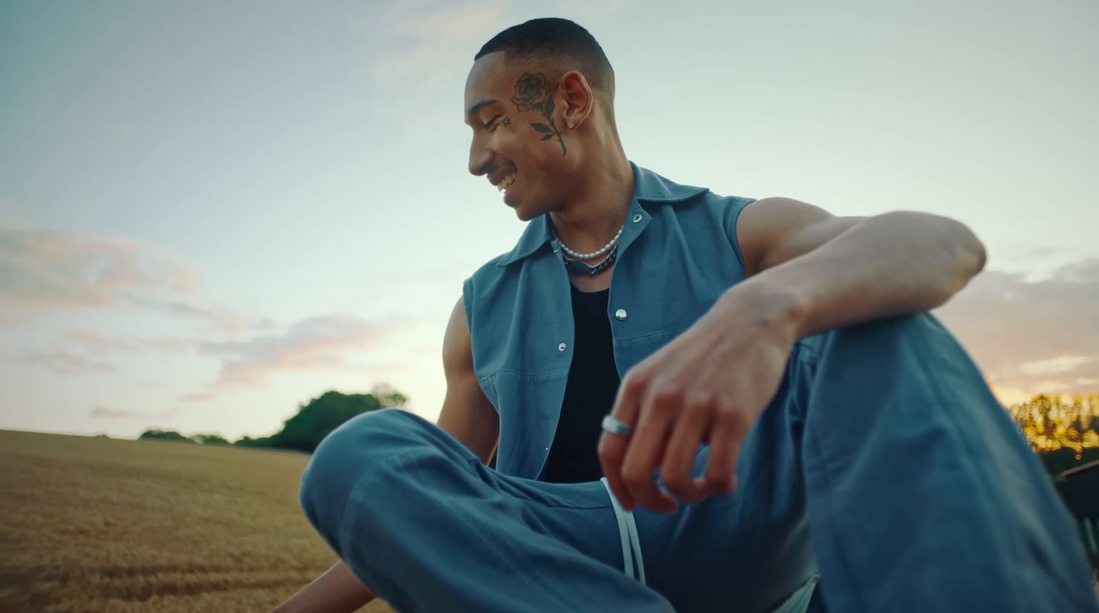 a man sitting on the ground in a field