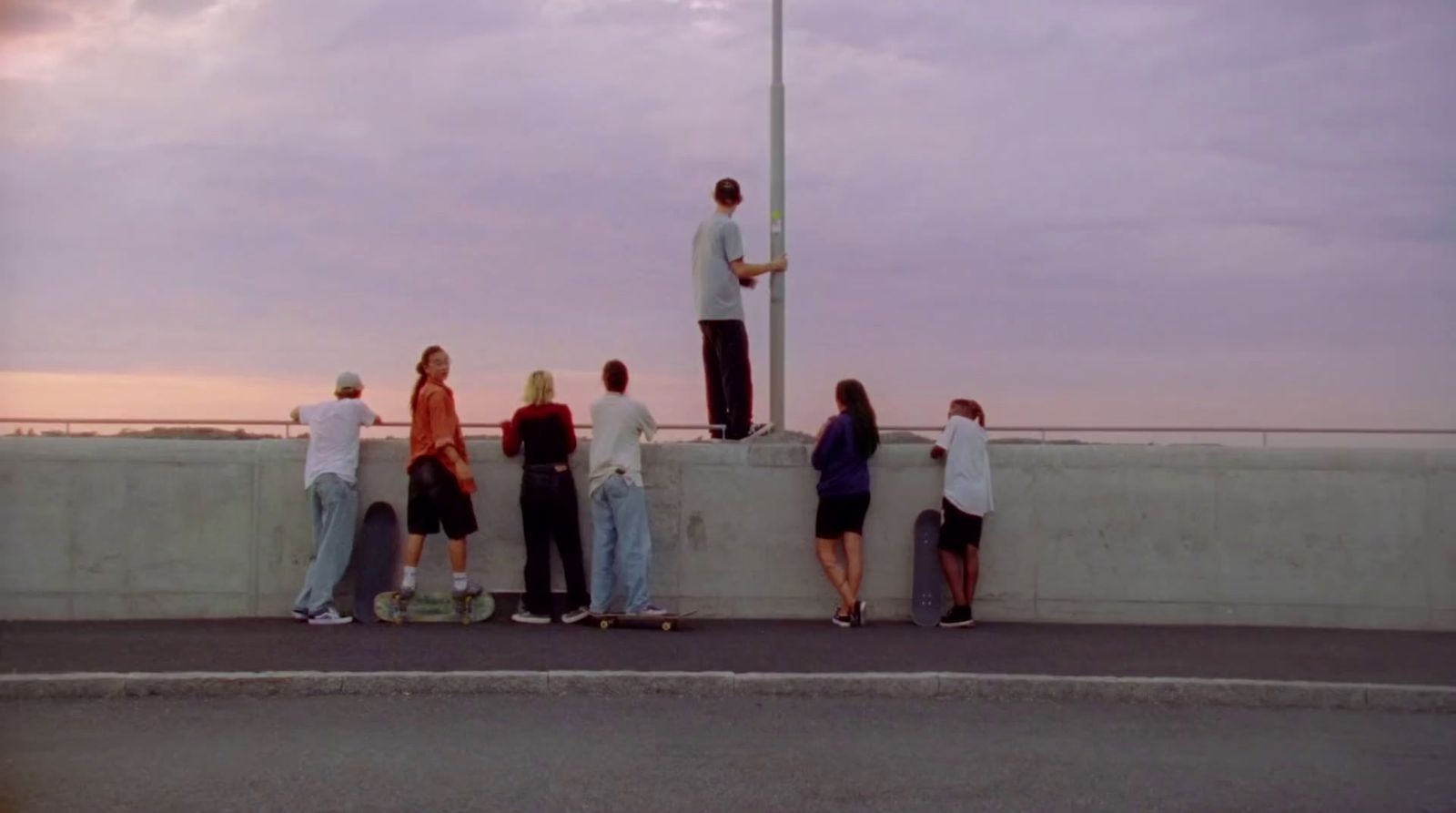 a group of people standing on the side of a road