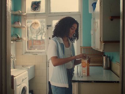 a woman standing in a kitchen next to a washing machine