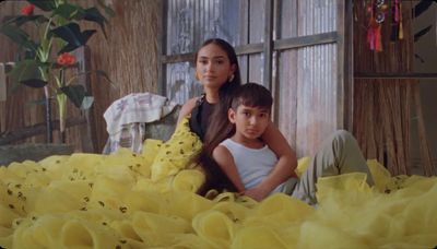 a woman sitting next to a boy in a room