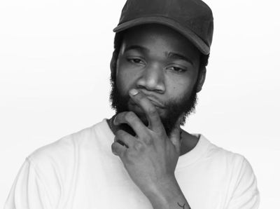 a black and white photo of a man wearing a hat