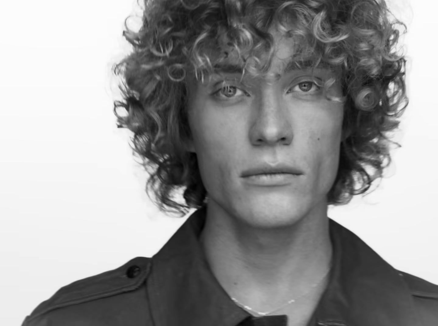 a black and white photo of a man with curly hair