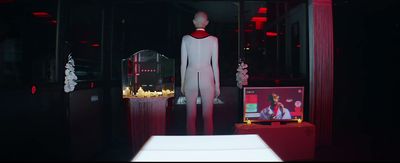 a white mannequin in a dark room with red lights