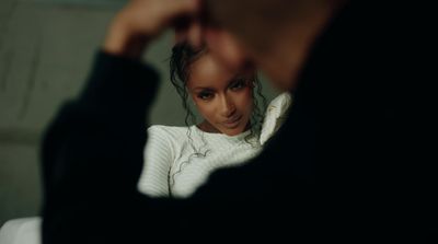 a woman in a white sweater looking at her reflection in a mirror