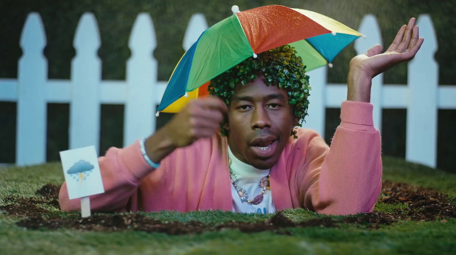 a man laying on the ground with an umbrella on his head