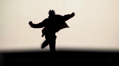 a silhouette of a man flying a kite