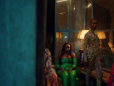 a group of women sitting next to each other in front of a window