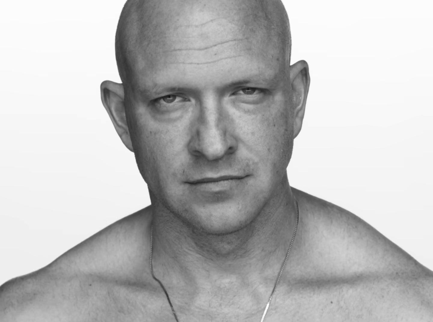 a black and white photo of a bald man