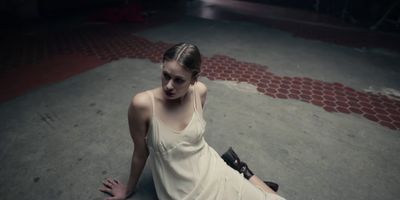 a woman sitting on the ground in a white dress