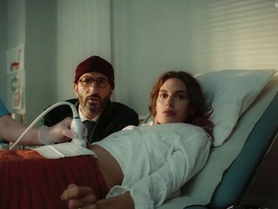 a man laying in a hospital bed next to a woman