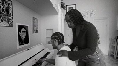 a man and a woman playing a piano together