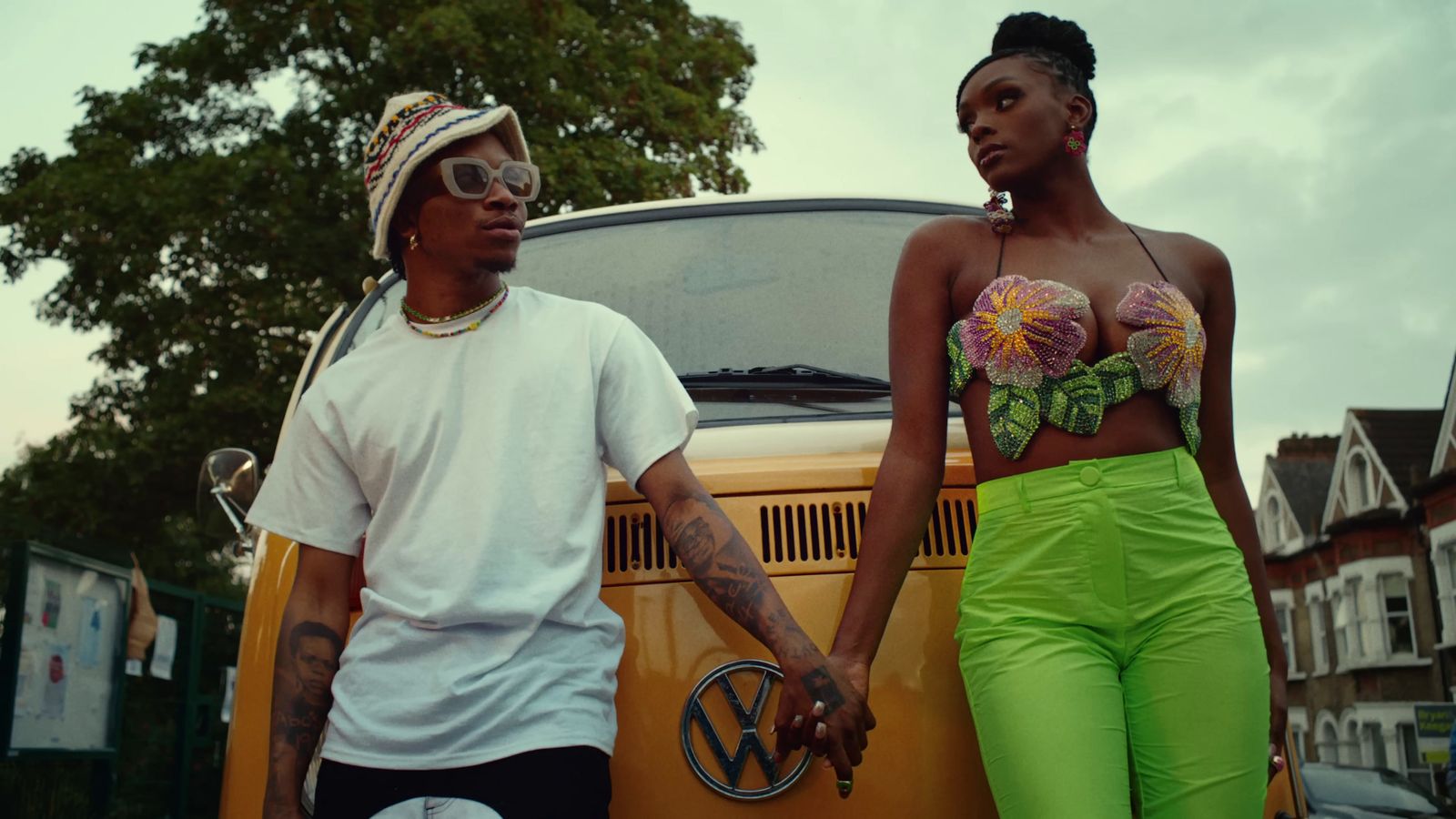 a man and a woman standing next to a vw bus