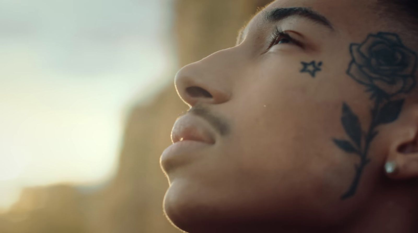 a man with a rose tattoo on his face