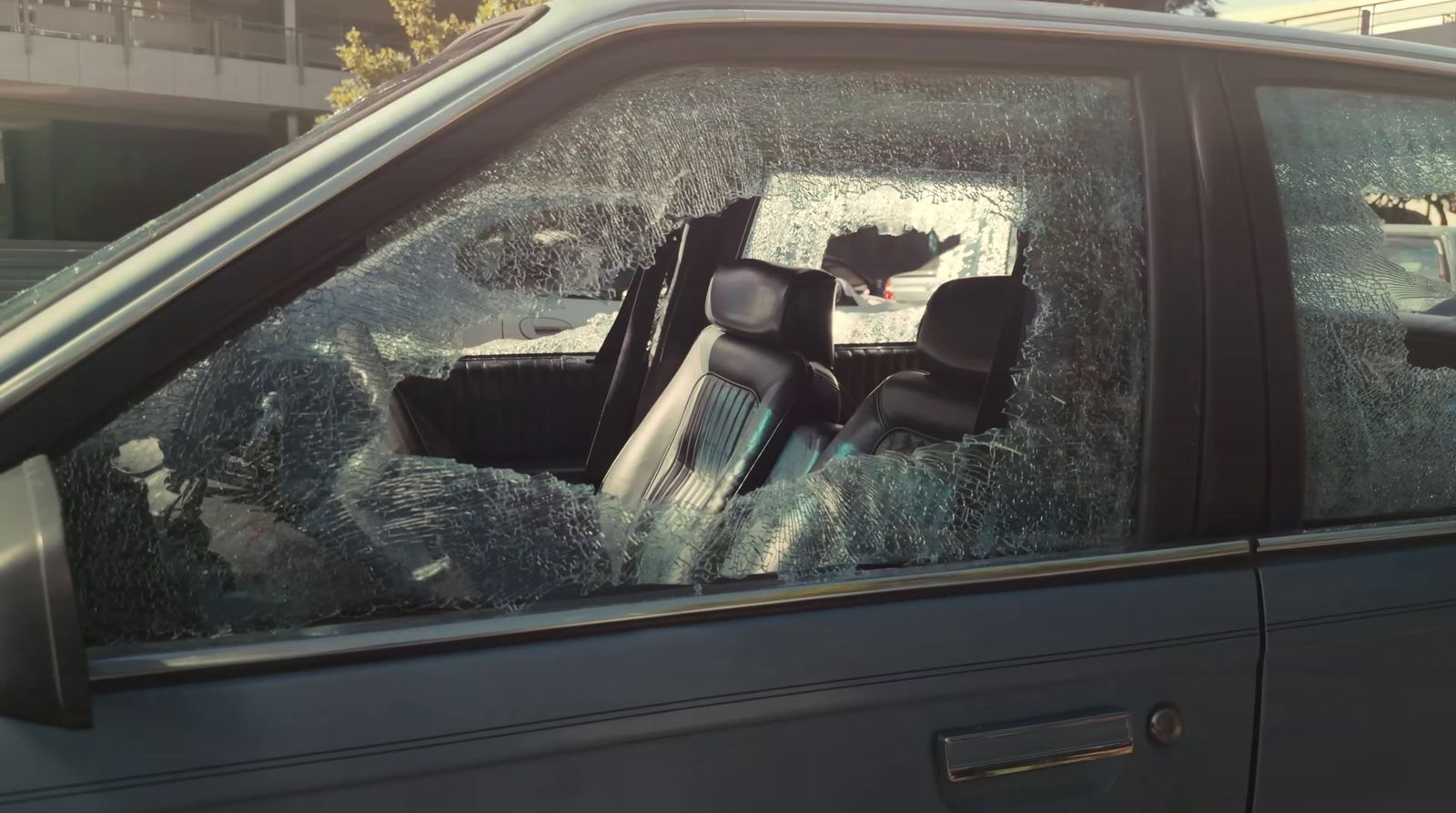 a car that is sitting in the street with a broken windshield