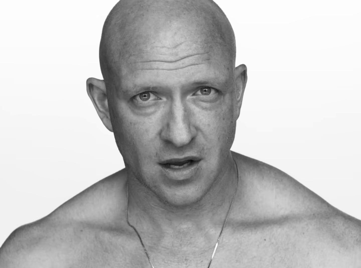 a black and white photo of a bald man