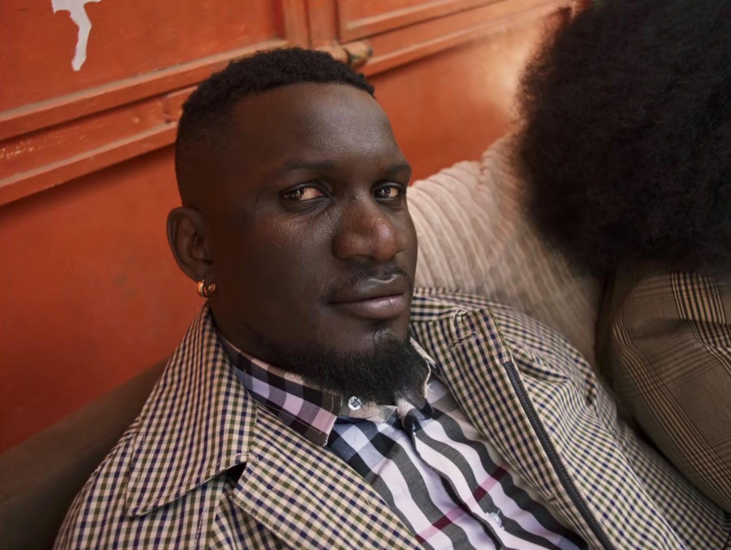 a man with an afro sitting next to a woman