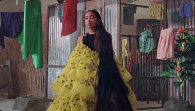 a woman in a yellow dress standing in a room