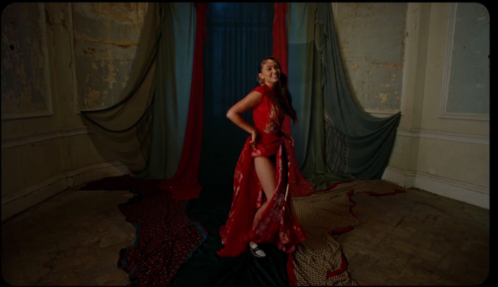 a woman in a red dress standing in a room