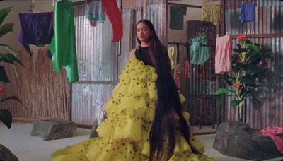 a woman in a yellow dress standing in a room