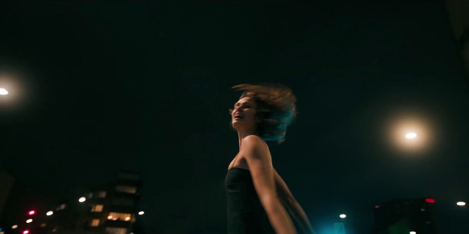 a woman walking down a street at night