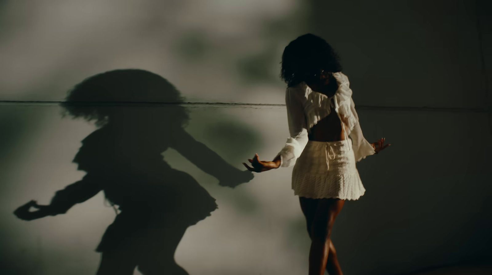 a shadow of a woman standing next to a wall