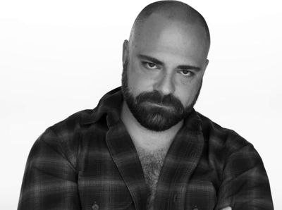 a man with a bald head wearing a plaid shirt