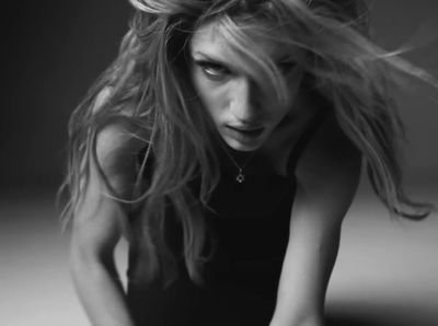 a black and white photo of a woman with her hair blowing in the wind