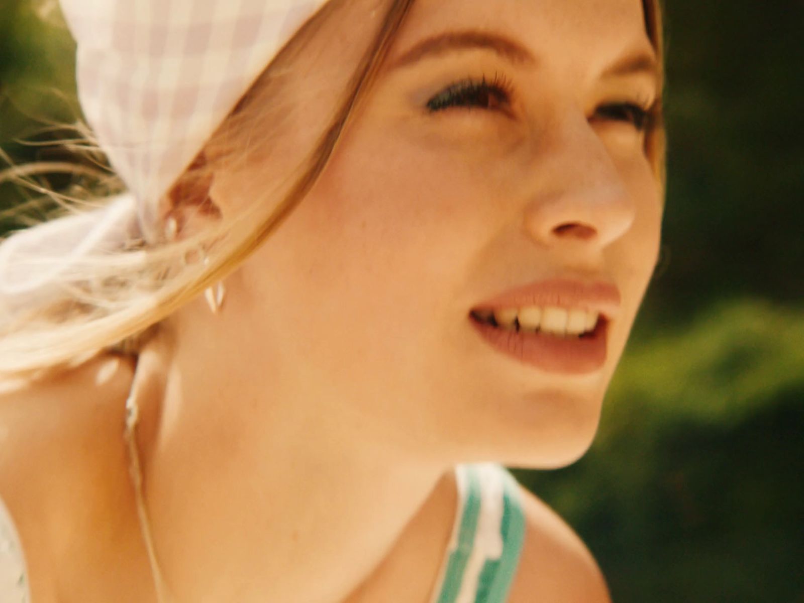 a woman wearing a white hat and a green and white dress