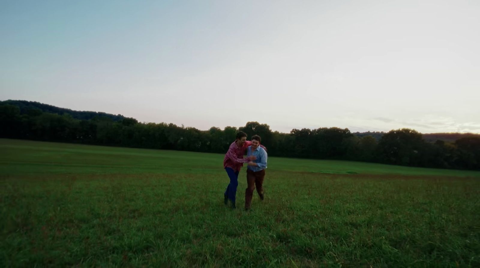 a couple of people that are standing in the grass