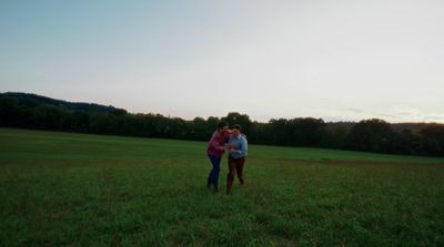 a couple of people that are standing in the grass