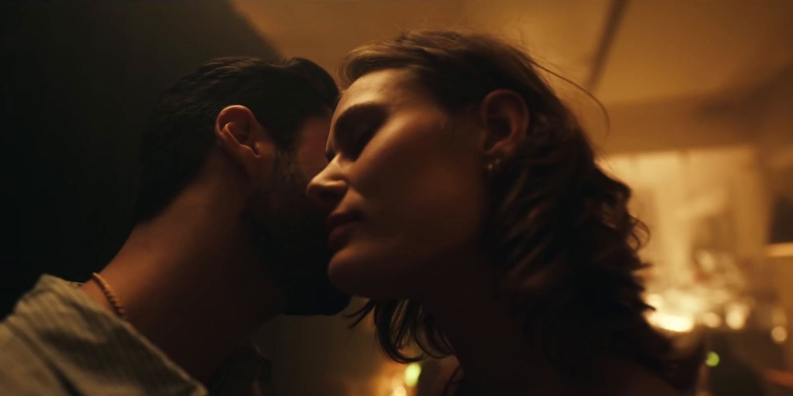 a man and a woman kissing in a dimly lit room