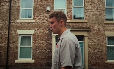 a man standing in front of a brick building